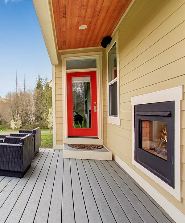 Composite decking with red door and fireplace in home siding