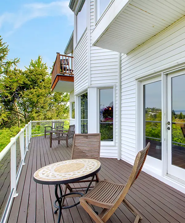 A home with white siding and a wood stained deck