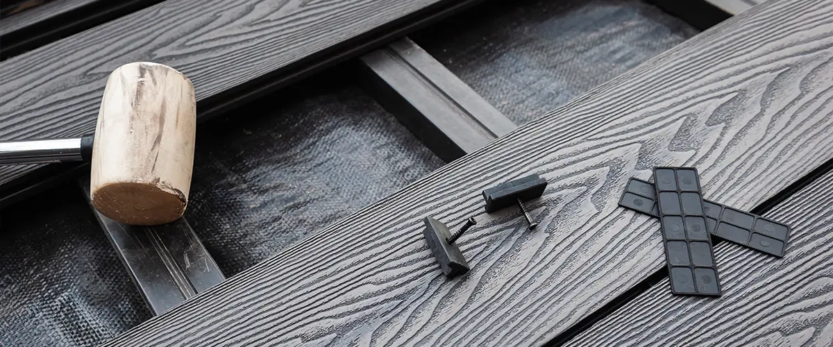 Dark composite decking with a wood mallet