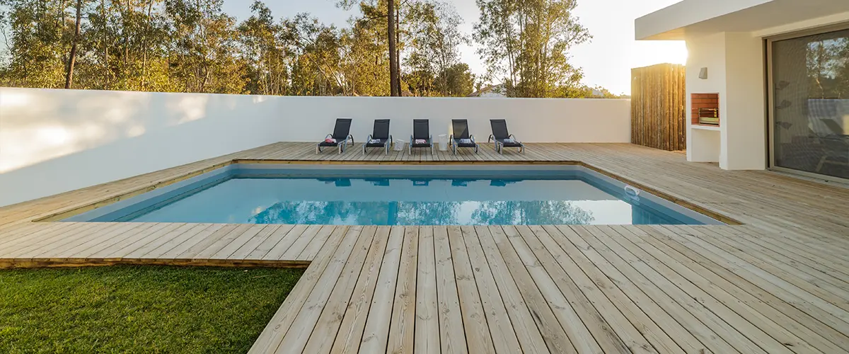 Wood decking around a pool and a small patch of grass
