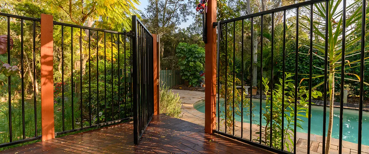 Metal fence on wood deck near a pool