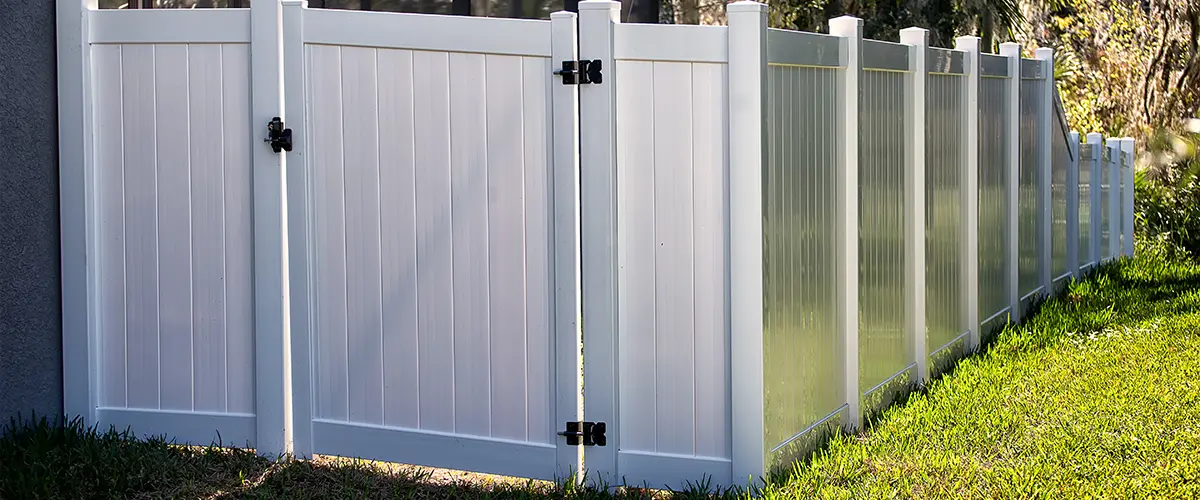 A white vinyl fence with no airflow and a gate