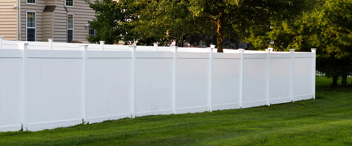 Vinyl privacy fence with a large patch of grass