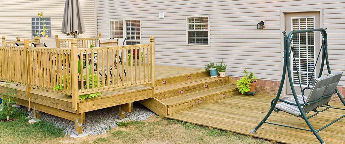 A pressure-treated wood deck with stairs and railing