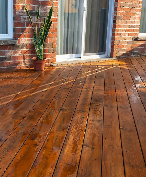 Cedar decking with a plant and brick home