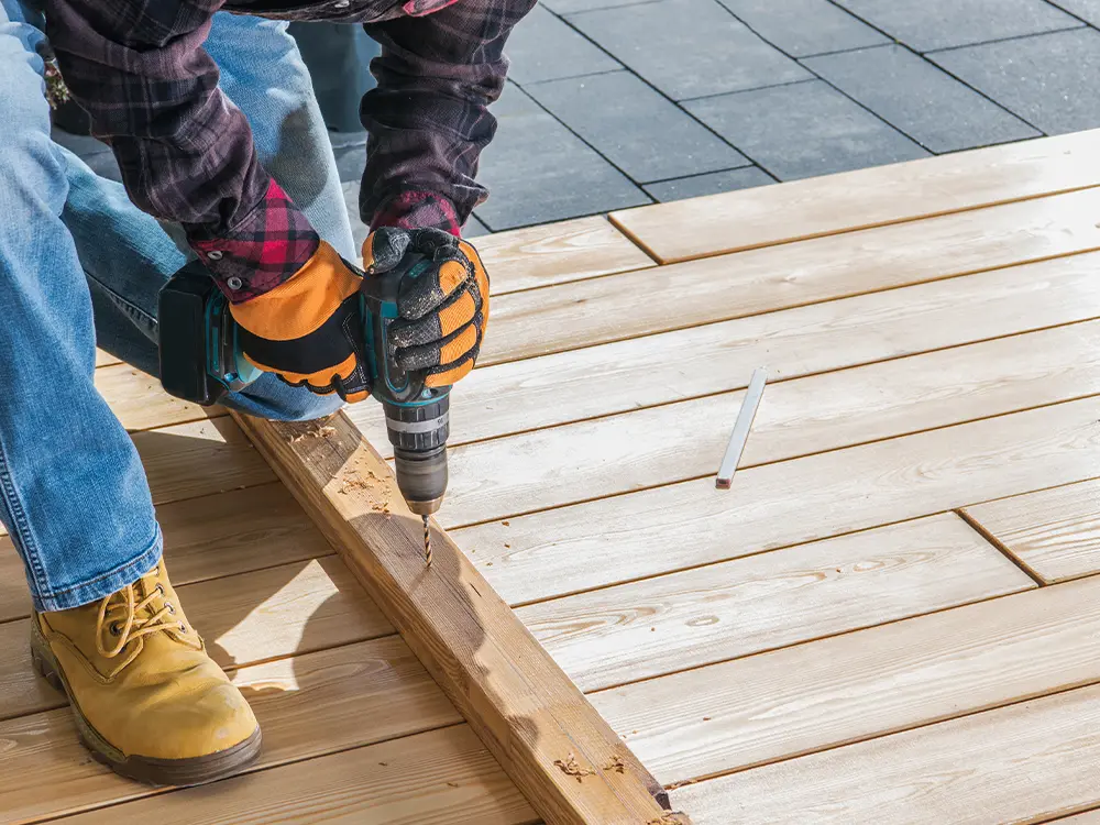 A deck builder in Washington repairing a wood deck