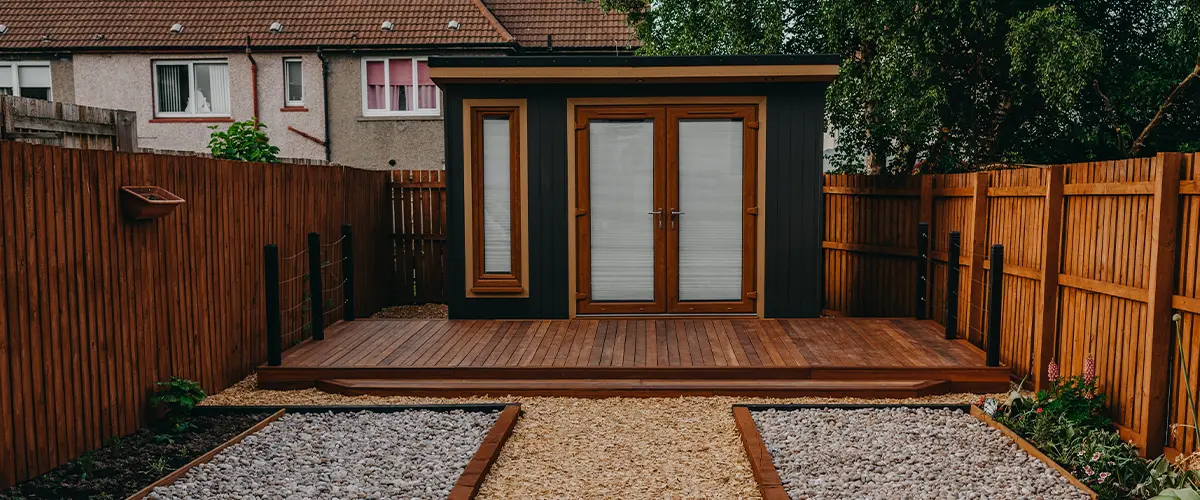 A wood decking around a shed and a cedar fence