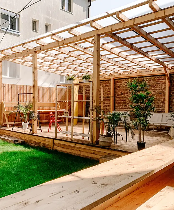 A wooden, covered deck with plants and furniture made by one of the best deck building companies in Woodinville