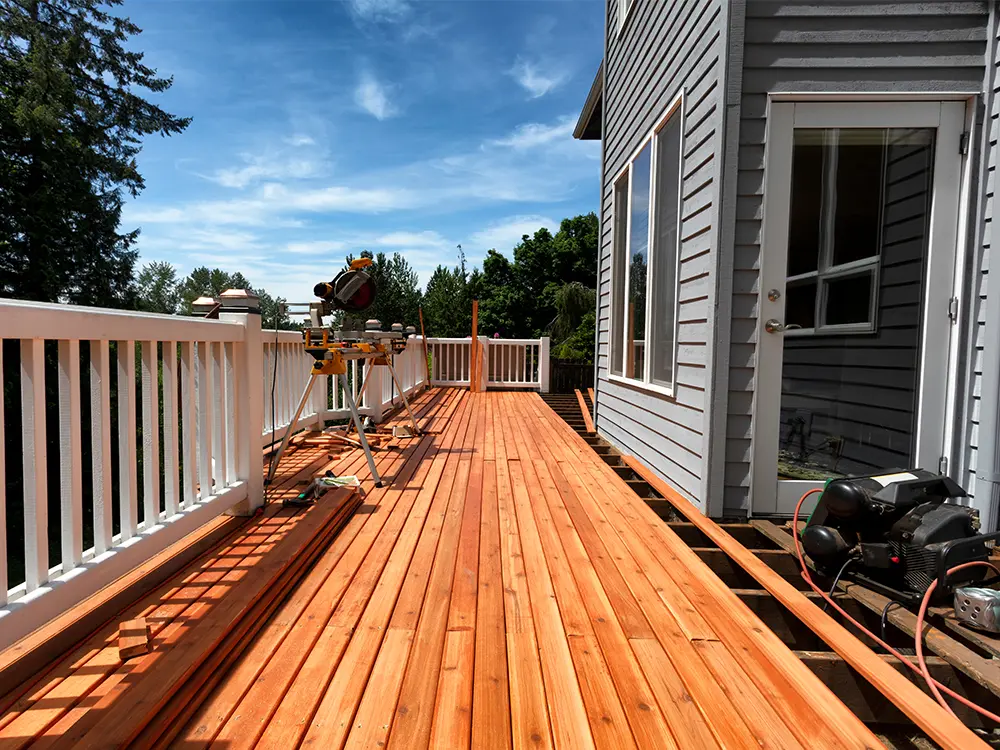 cedar decking installation with white metal railing
