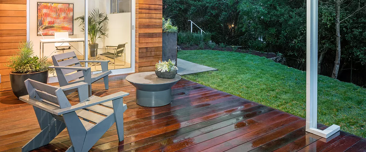 Wet Wooden deck, balcony at night with furniture and open doors, deck water drainage system